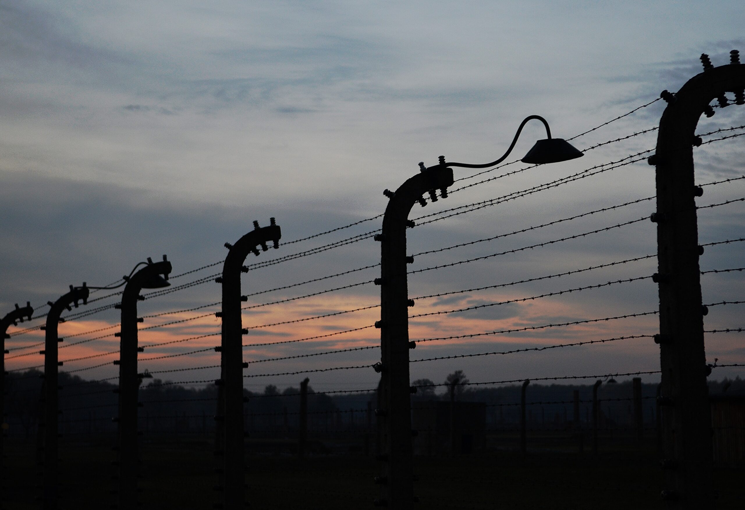 Vista de los alambrados exteriores del campo de concentración de Auschwitz en el atardecer